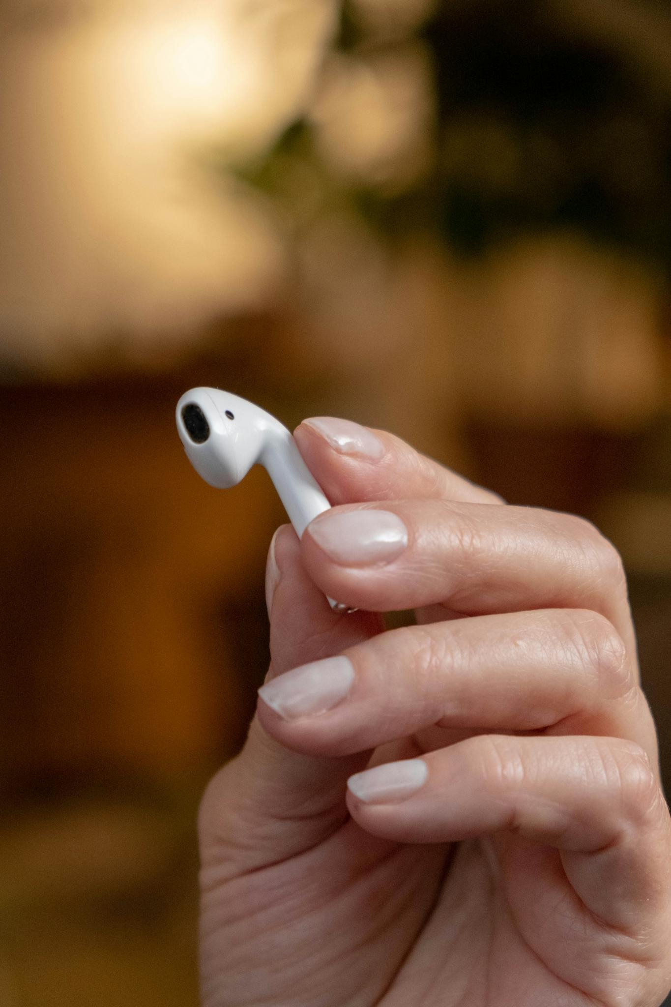 Home 1 Wireless earbud held in hand, showcasing modern technology and design. Ideal for tech-related themes.